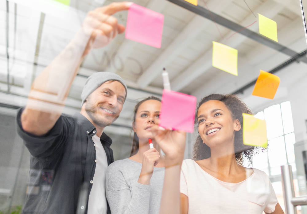 People working around a whiteboard with post-it