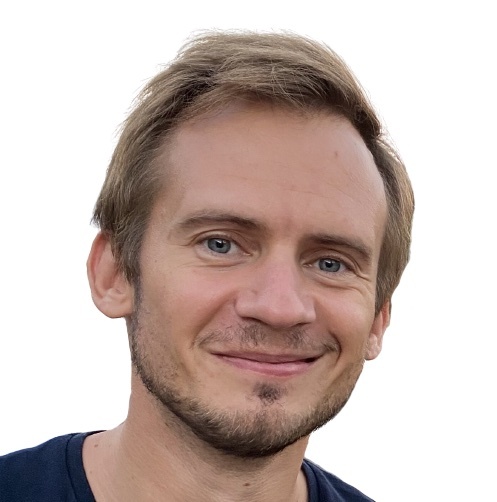 The headshot of a young man smiling at the camera.
